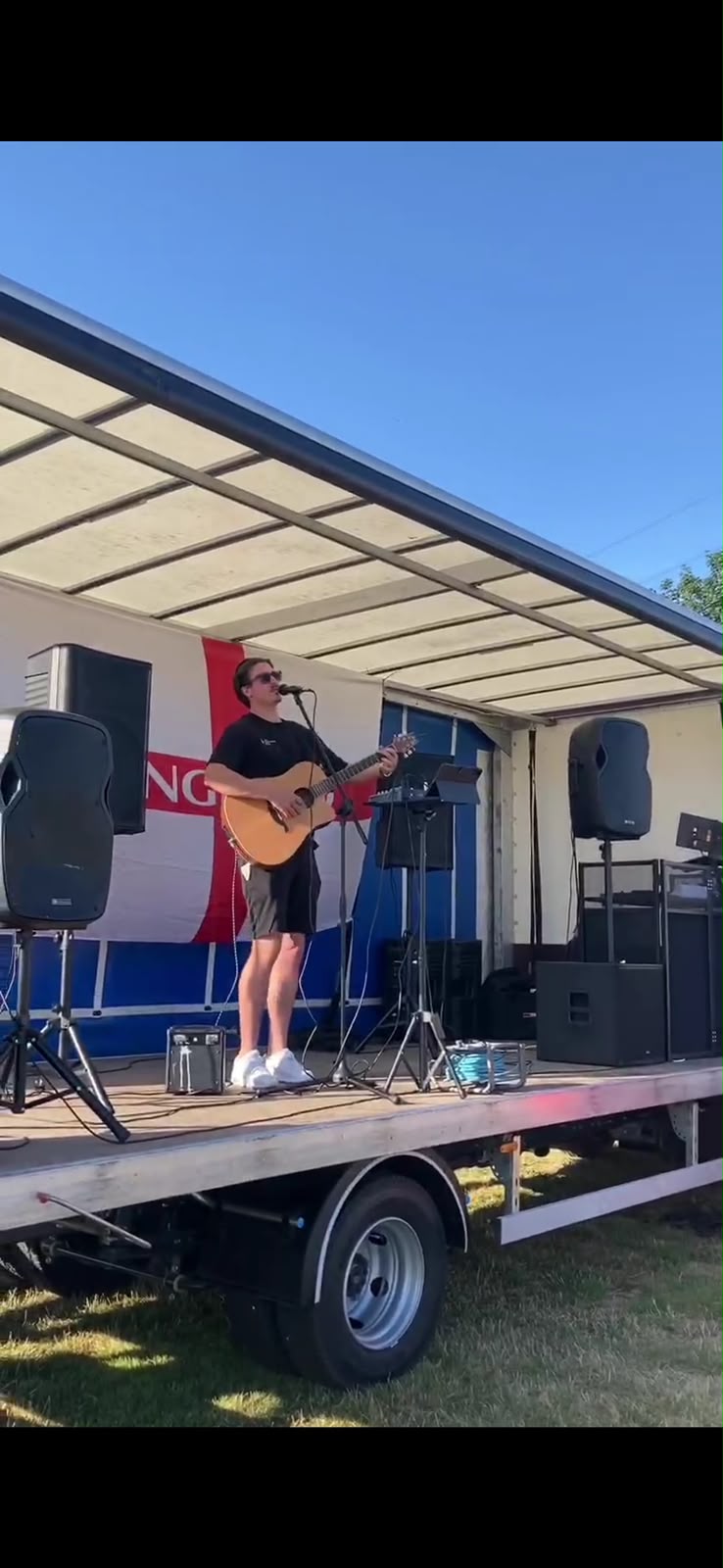 Sam Hackney performing live on an outdoor stage